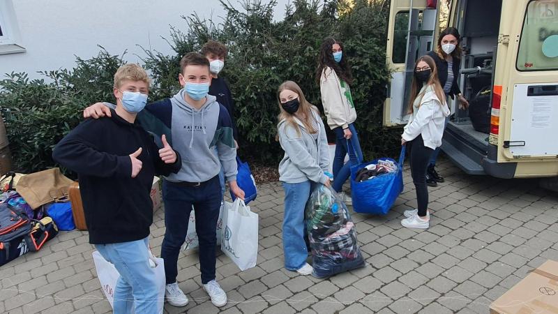 Sch�ler packen die Sachspenden in ein Fahrzeug des DRK