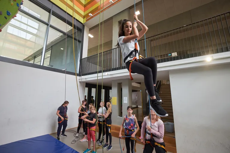 Schülergruppe an der Kletterwand