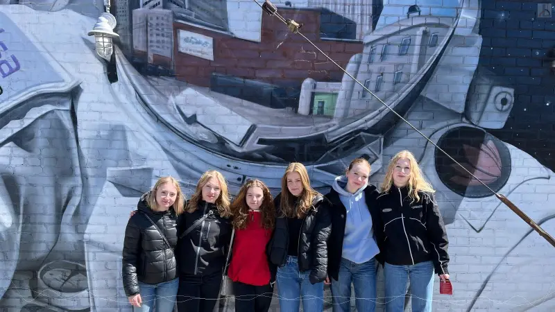 M�delsgruppe vor Astronaut-Graffiti