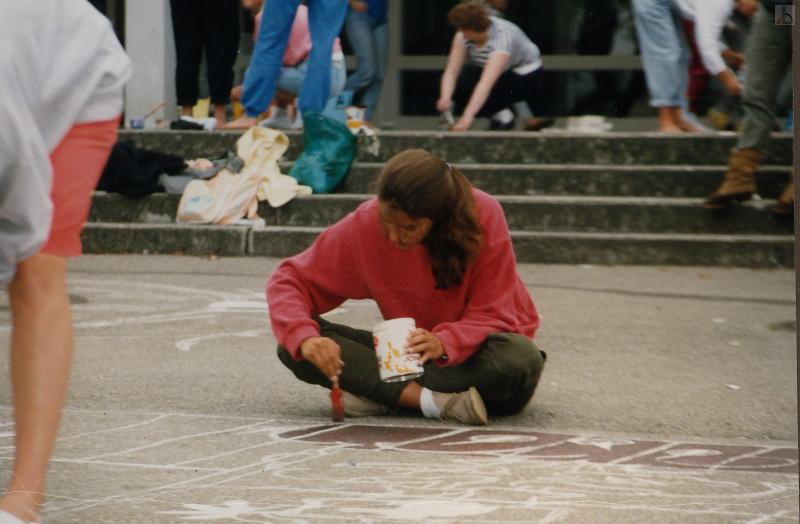 Schülerin malt mit Kreide auf dem Schulhof